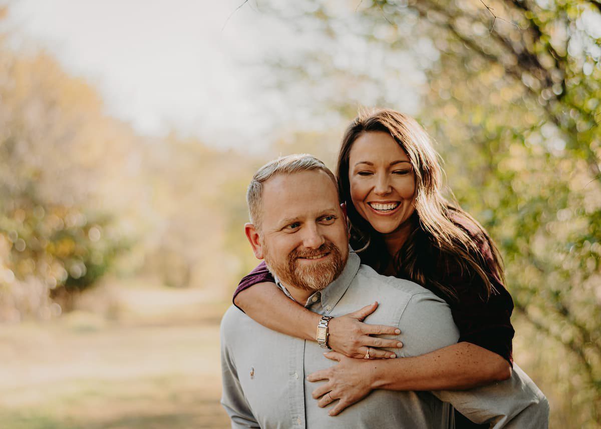 Smiling man and woman hugging outdoors